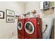 The laundry room features a red side-by-side washer and dryer set with above shelving at 3302 Granite Ridge Loop, Land O Lakes, FL 34638