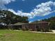A cozy single-story red brick home with a neatly maintained lawn and partial view of the sky at 3419 Pearson Rd, Valrico, FL 33596