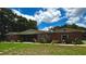 Charming single-story red brick home with a covered porch and beautiful landscaping at 3419 Pearson Rd, Valrico, FL 33596