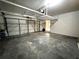 Empty two-car garage featuring overhead storage rack at 3419 Pearson Rd, Valrico, FL 33596