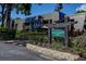 Attractive condo complex exterior with lush landscaping and a sign at 36750 Us 19 N # 24-213, Palm Harbor, FL 34684
