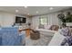 Comfortable living room with modern entertainment center, wood flooring, and bright, natural lighting at 36750 Us 19 N # 24-213, Palm Harbor, FL 34684