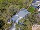 Aerial view showcasing a home with a screened pool and lush surrounding trees at 4202 Deepwater Ln, Tampa, FL 33615