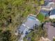 Aerial view showcasing a home with a screened pool and lush surrounding trees at 4202 Deepwater Ln, Tampa, FL 33615