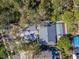 Aerial view showcasing a home with a screened pool and lush surrounding trees at 4202 Deepwater Ln, Tampa, FL 33615