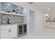 Chic bar area with wine fridge, mosaic tile backsplash, custom cabinetry, and sleek black faucet at 4202 Deepwater Ln, Tampa, FL 33615