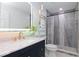 Bathroom featuring modern vanity, shower with decorative tile accents and heated towel rack at 4202 Deepwater Ln, Tampa, FL 33615