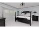 Bright bedroom boasts large bay window with shutters, tray ceiling, and black accent furniture at 4202 Deepwater Ln, Tampa, FL 33615