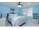 Cozy bedroom with a ceiling fan, shuttered window, and cool blue accent walls at 4202 Deepwater Ln, Tampa, FL 33615