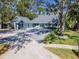 Charming home featuring a spacious driveway, lush landscaping, and inviting front porch at 4202 Deepwater Ln, Tampa, FL 33615