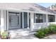 Charming front porch with detailed woodwork, a hanging lantern, and beautiful shrubbery at 4202 Deepwater Ln, Tampa, FL 33615