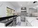 Bright kitchen features stainless steel appliances, island seating, and a view to the outside at 4202 Deepwater Ln, Tampa, FL 33615