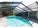 Screened-in pool with brick patio and covered lanai, surrounded by lush landscaping at 4202 Deepwater Ln, Tampa, FL 33615