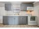 Well-lit kitchen area with gray cabinets, modern appliances, and durable tile flooring at 4527 W Minnehaha St, Tampa, FL 33614
