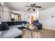 Cozy living room featuring a comfortable sectional sofa, ceiling fan, and decorative mirror above the couch at 4527 W Minnehaha St, Tampa, FL 33614