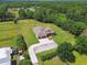 Aerial view showcasing a home with a circular driveway, landscaping, mature trees and horse fencing at 4608 Scott Rd, Lutz, FL 33558