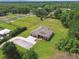 Aerial view of a home with a large yard, horse fencing, mature trees, and landscaping at 4608 Scott Rd, Lutz, FL 33558