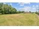 Large backyard with mature trees, lush grass, and a charming gazebo-style shelter at 4608 Scott Rd, Lutz, FL 33558