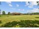 Expansive backyard features lush green grass, open space, a charming single-story home and fire pit at 4608 Scott Rd, Lutz, FL 33558