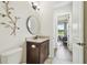 Modern bathroom vanity featuring a round mirror, elegant faucet and granite countertop at 4608 Scott Rd, Lutz, FL 33558