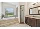 Bright bathroom featuring a soaking tub, walk-in shower, and granite countertop vanity at 4608 Scott Rd, Lutz, FL 33558