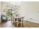 Bright dining room with a large window, wood-look tile flooring, and stylish furniture at 4608 Scott Rd, Lutz, FL 33558