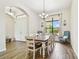 Bright dining room with elegant chandelier, large windows, and wood-look tile flooring at 4608 Scott Rd, Lutz, FL 33558