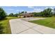 Long driveway leading to a home with a three-car garage and landscaped surroundings at 4608 Scott Rd, Lutz, FL 33558