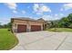 Stunning home featuring a three-car garage, stone accents, manicured lawn, and inviting curb appeal at 4608 Scott Rd, Lutz, FL 33558