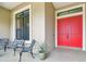 Inviting front porch with double red doors, seating, and a potted plant, perfect for relaxing at 4608 Scott Rd, Lutz, FL 33558
