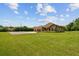 Beautifully landscaped front yard with lush green grass and a home with stone accents and a three-car garage at 4608 Scott Rd, Lutz, FL 33558