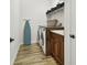 Laundry room featuring a washer and dryer, utility sink, storage shelves, and wood-look floors at 4608 Scott Rd, Lutz, FL 33558