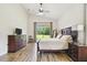Serene main bedroom with a ceiling fan, wood-look tile flooring, and a view of the backyard at 4608 Scott Rd, Lutz, FL 33558