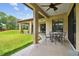 Covered patio dining area with view of expansive, well-maintained lawn and mature trees at 4608 Scott Rd, Lutz, FL 33558