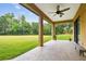 Covered patio with ceiling fan overlooks the sprawling backyard and lush greenery at 4608 Scott Rd, Lutz, FL 33558