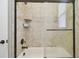 Shower stall featuring tile surround, sliding glass door, bronze showerhead, and built-in niche at 4608 Scott Rd, Lutz, FL 33558