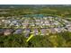 A captivating aerial shot showcasing a serene residential neighborhood nestled amidst a tranquil lake and lush landscapes at 5446 Suncatcher Dr, Wesley Chapel, FL 33545