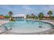 Large community swimming pool surrounded by lounge chairs, palm trees, and lush landscaping at 5446 Suncatcher Dr, Wesley Chapel, FL 33545