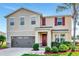 Charming two-story home with a well-manicured front yard and a modern gray garage door at 5446 Suncatcher Dr, Wesley Chapel, FL 33545