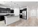 Modern kitchen with dark cabinets, stainless steel appliances, and a large center island with granite countertops at 5446 Suncatcher Dr, Wesley Chapel, FL 33545