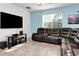 Living room featuring a comfortable leather sectional sofa and entertainment center at 5446 Suncatcher Dr, Wesley Chapel, FL 33545