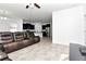 Comfortable living room with kitchen view, featuring a leather sectional sofa and modern appliances at 5446 Suncatcher Dr, Wesley Chapel, FL 33545