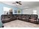 Spacious living room with a large leather sectional sofa and bright natural light at 5446 Suncatcher Dr, Wesley Chapel, FL 33545