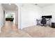 A carpeted office space with neutral colored walls, next to the tile-floored entryway and adjacent living space at 5446 Suncatcher Dr, Wesley Chapel, FL 33545