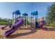 Another angle of the community playground with slides and play structures for children at 5446 Suncatcher Dr, Wesley Chapel, FL 33545