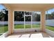 View of the backyard from screened patio, showcasing outdoor living space and lush greenery at 5446 Suncatcher Dr, Wesley Chapel, FL 33545