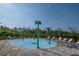 Community splash pad featuring palm tree water features, lounge chairs, and lush landscaping at 5446 Suncatcher Dr, Wesley Chapel, FL 33545