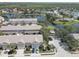 Wonderful aerial view of lovely townhomes in a lake community with trees and ample parking spaces at 580 Shoreham Ne Ct, St Petersburg, FL 33716
