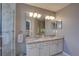 Bathroom features a double sink vanity with granite countertops, bright lighting, and a glass shower at 580 Shoreham Ne Ct, St Petersburg, FL 33716