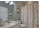 Inviting bathroom featuring a shower and tub combination with palm-themed decor and marble countertops at 580 Shoreham Ne Ct, St Petersburg, FL 33716